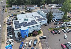 Commercial solar installation case studies on Honda dealership with rooftop solar panels and parking lot.