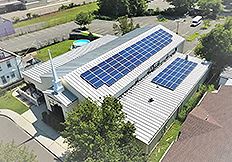 Commercial solar installation on Cathedral of Faith roof with metal panels and multiple solar arrays.