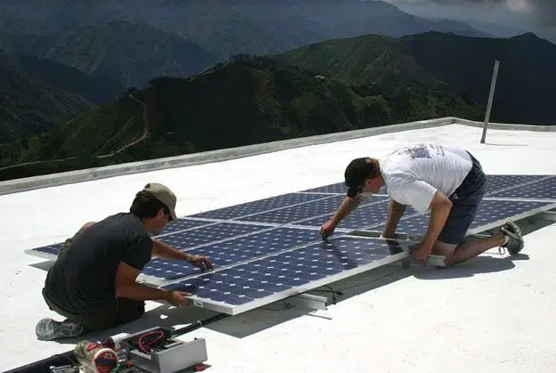 Commercial solar installation team performing Solar PV panel installation as part of a commercial solar service project.